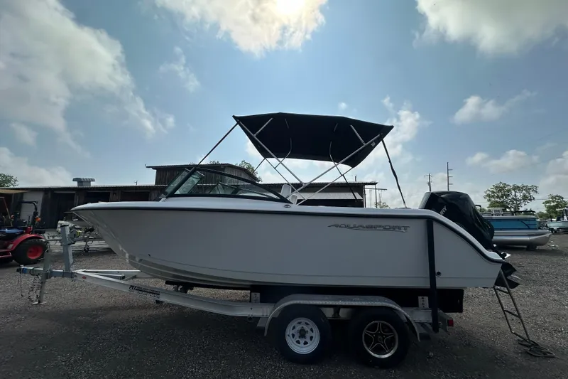 Slide: The Image of 2024 Aquasport 2200 Dual Console boat on trailer under a cloudy sky. - 45