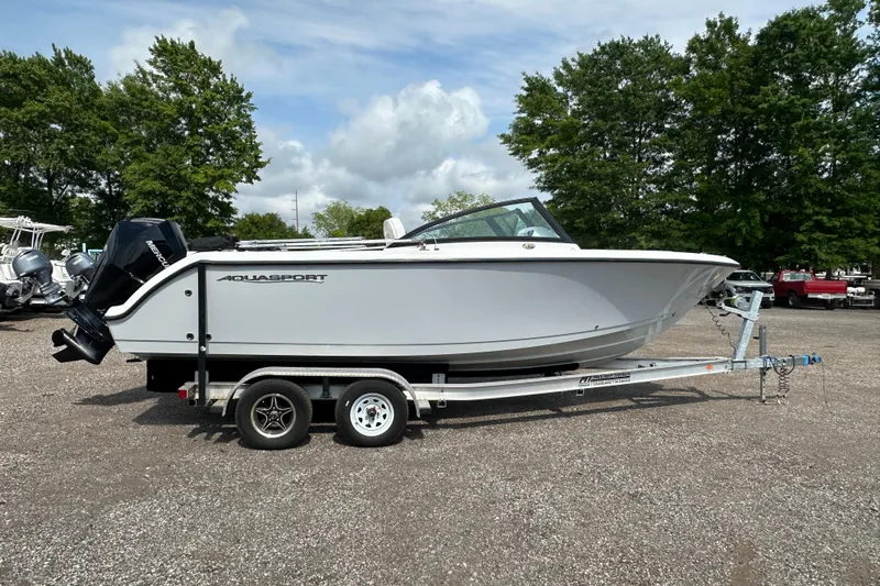 Slide: The Image of 2024 Aquasport 2200 Dual Console boat on trailer, parked outdoors. - 7