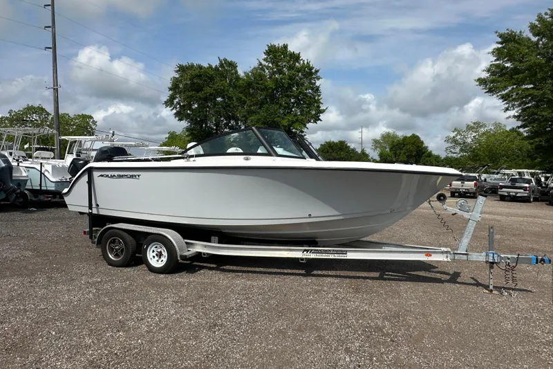 Slide: The Image of 2024 Aquasport 2200 Dual Console boat on trailer, parked outdoors. - 8