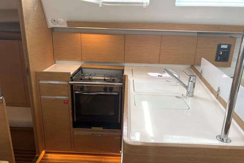 Slide: The Image of Modern kitchen in 2018 Elan Impression yacht with stove, sink, and wooden cabinetry. - 14