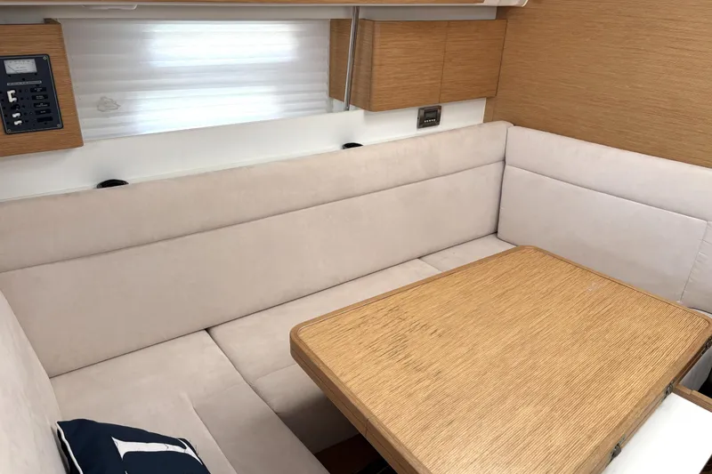 Slide: The Image of Cozy interior of 2018 Elan Impression yacht with beige seating and wooden table. - 21