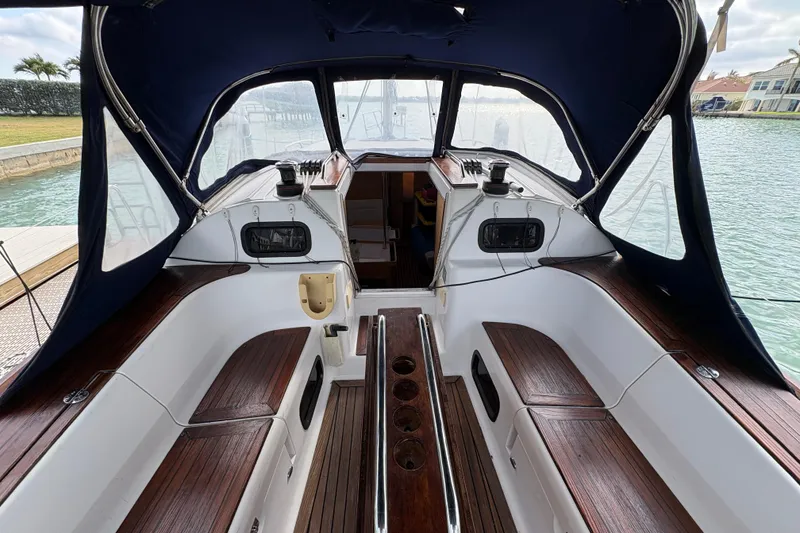 Slide: The Image of 2018 Elan Impression yacht cockpit with wooden seating and canopy, docked by the water. - 4