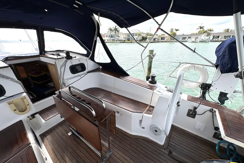 Slide: The Image of Cockpit of 2018 Elan Impression yacht with wooden seating and marina view. - 5