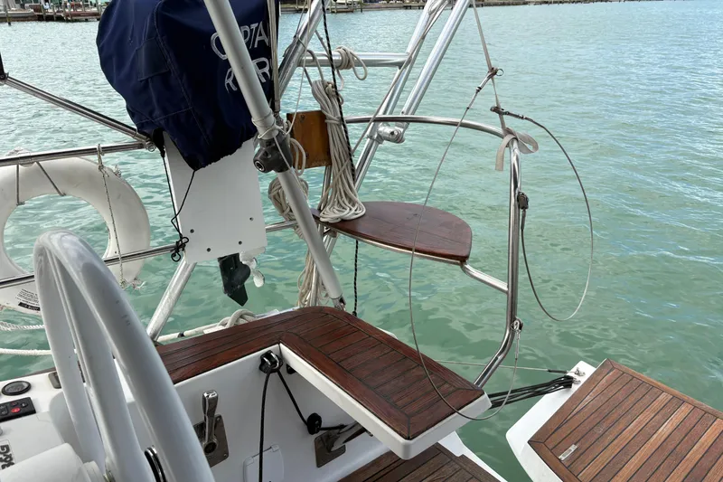 Slide: The Image of Sailboat deck with wooden steps and railing, Elan Impression 2018, docked by calm water. - 8