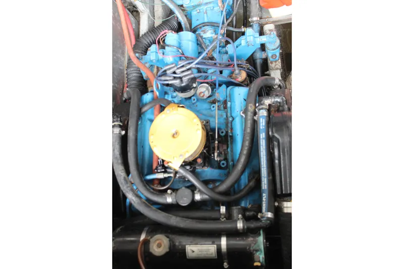 Slide: The Image of Engine of a 1980 Carver 280 Voyager boat, featuring blue components and hoses. - 12