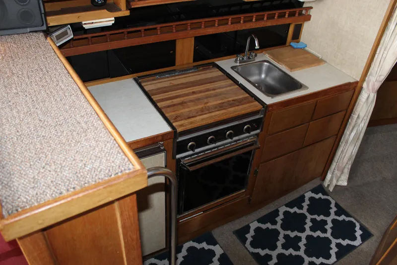 Slide: The Image of 1980 Carver 280 Voyager kitchen with stove, sink, and wooden cabinetry. - 17