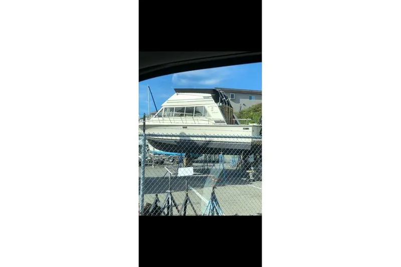 Slide: The Image of 1980 Carver 280 Voyager boat on dry dock behind a chain-link fence. - 26