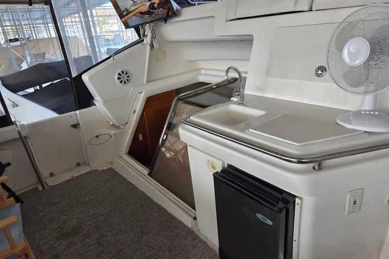 Slide: The Image of 1998 Silverton 372 Motor Yacht interior with kitchenette, sink, and fan. - 12