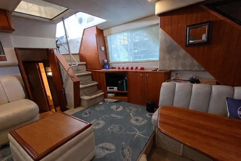Slide: The Image of Interior of a 1998 Silverton 372 Motor Yacht with cozy seating and wooden accents. - 16