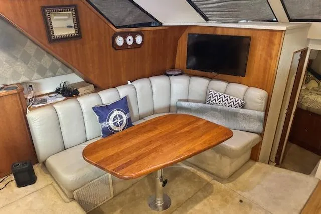 Slide: The Image of Interior of 1998 Silverton 372 Motor Yacht with cozy seating and wooden table. - 18