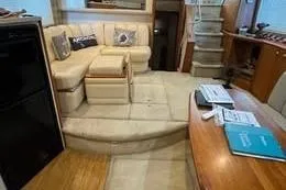 Slide: The Image of 1998 Silverton 372 Motor Yacht interior with beige seating and wooden accents. - 21