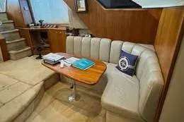 Slide: The Image of 1998 Silverton 372 Motor Yacht interior with cozy seating and wooden table. - 22