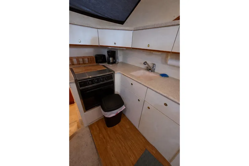 Slide: The Image of 1998 Silverton 372 Motor Yacht kitchen with stove, sink, and cabinets. - 23