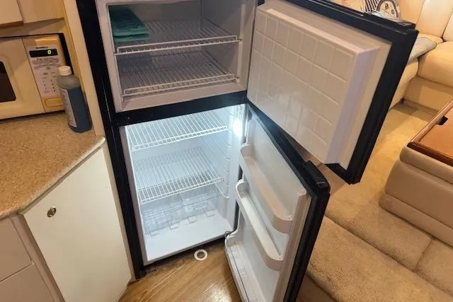Slide: The Image of Open refrigerator inside 1998 Silverton 372 Motor Yacht, showcasing spacious interior and shelves. - 26