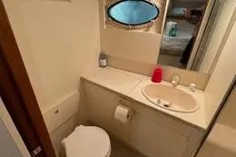 Slide: The Image of 1998 Silverton 372 Motor Yacht bathroom with sink, toilet, and porthole window. - 32