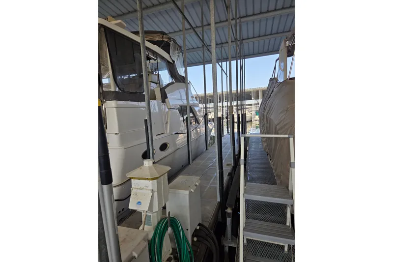 Slide: The Image of 1998 Silverton 372 Motor Yacht docked in a covered marina slip. - 6