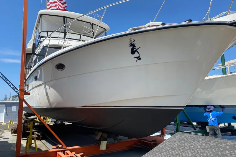 Slide: The Image of 1988 Vantare 46' Aft Cabin Wide Body MY yacht on dry dock, featuring mermaid decal. - 74