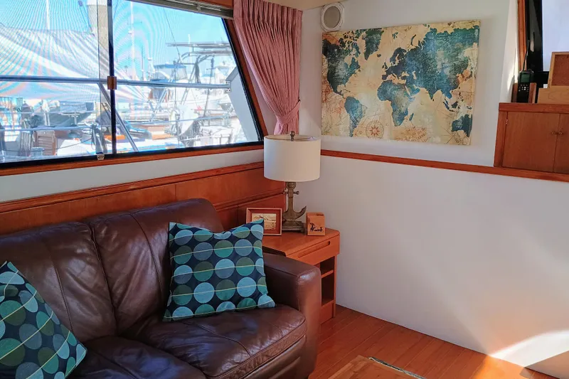 Slide: The Image of Interior of 1988 Vantare 46' yacht with leather sofa, map decor, and marina view. - 12