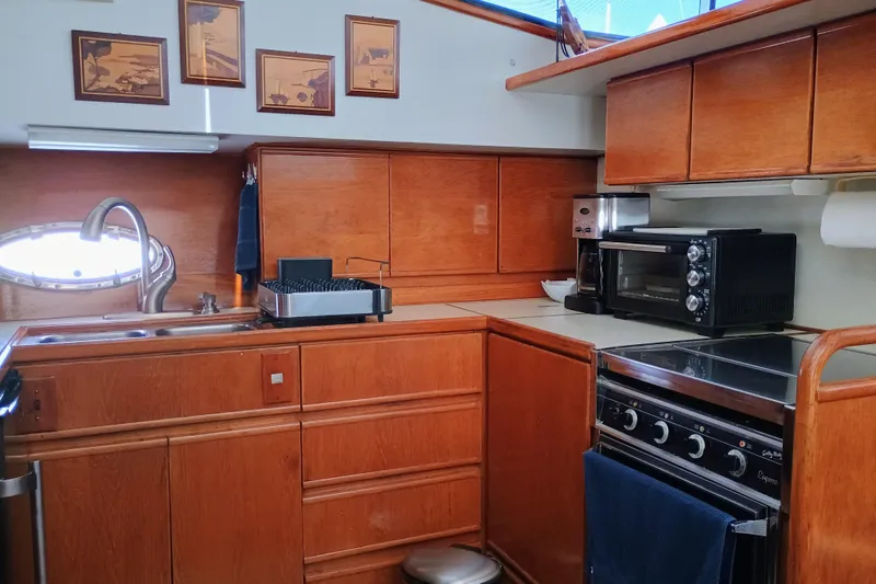 Slide: The Image of 1988 Vantare 46' yacht kitchen with wood cabinetry, oven, and sink. - 22