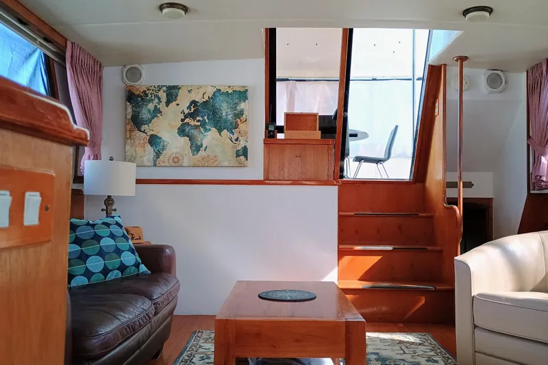 Slide: The Image of Interior of 1988 Vantare 46' Aft Cabin Wide Body MY with cozy seating and world map decor. - 30