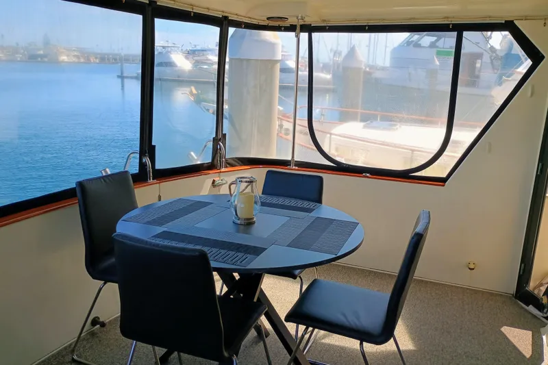 Slide: The Image of Interior of 1988 Vantare 46' Aft Cabin yacht with dining area and marina view. - 45