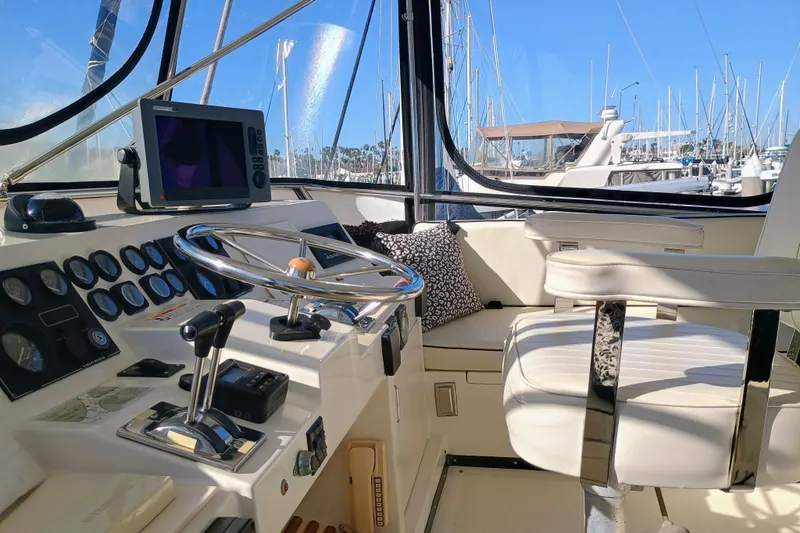 Slide: The Image of 1988 Vantare 46' Aft Cabin Wide Body MY helm with steering wheel and navigation equipment. - 48