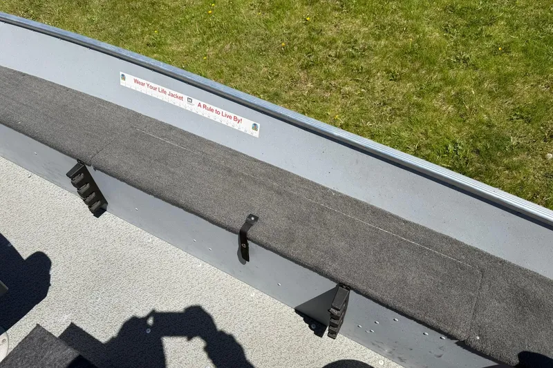 Slide: The Image of Interior of 2013 Lund 1600 Fury Tiller boat with safety sign and grassy background. - 14