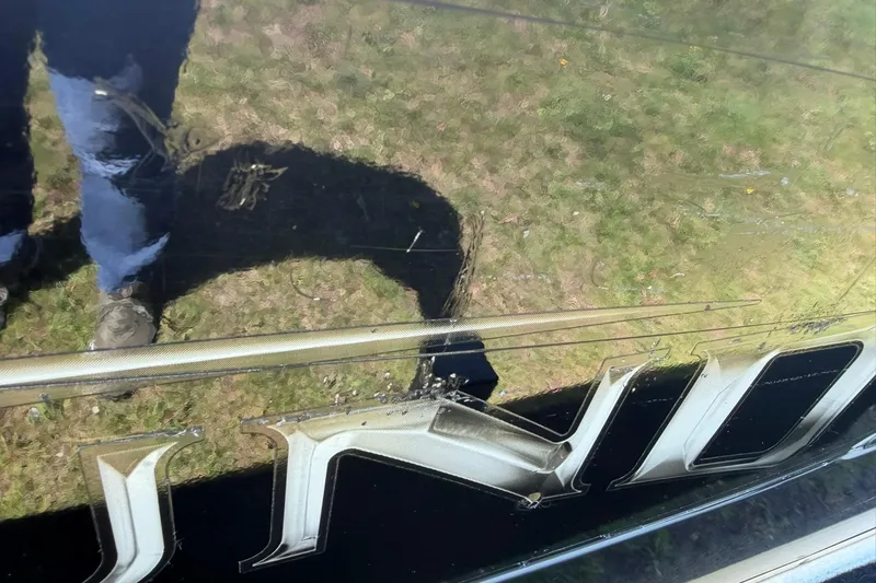 Slide: The Image of Reflection on Lund 1600 Fury Tiller boat surface, 2013 model, showing grass and person. - 25