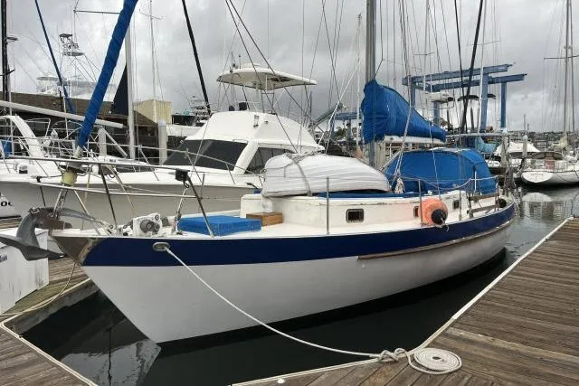The Image of 1977 Uniflite Valiant 40 sailboat docked at marina, featuring blue and white hull. - 1