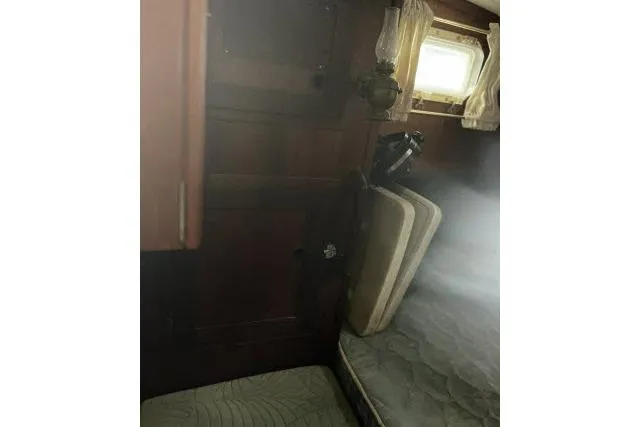 Slide: The Image of Interior cabin of 1977 Uniflite Valiant 40 sailboat with wooden paneling and bedding. - 17