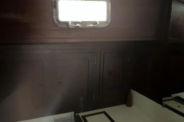 Slide: The Image of Interior of 1977 Uniflite Valiant 40 yacht with wooden cabinets and a small window. - 20