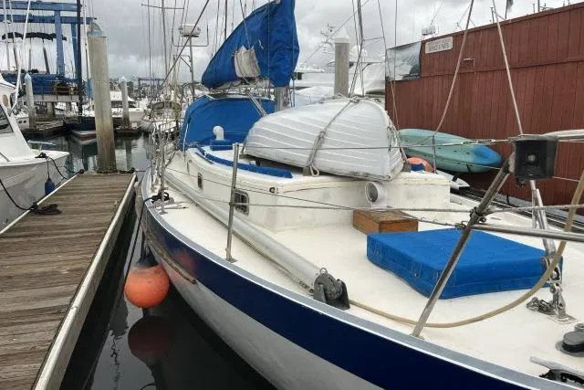 Slide: The Image of 1977 Uniflite Valiant 40 sailboat docked at marina with blue accents. - 24