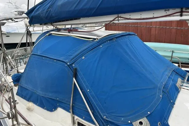 Slide: The Image of 1977 Uniflite Valiant 40 sailboat with blue canvas cover at dock. - 25