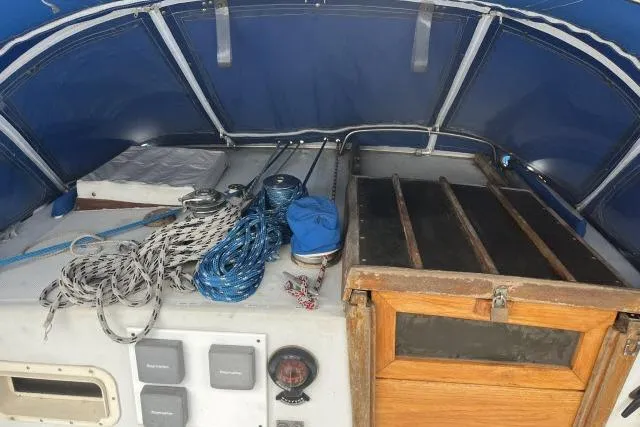 Slide: The Image of 1977 Uniflite Valiant 40 sailboat cockpit with ropes, winches, and wooden hatch under blue canopy. - 30