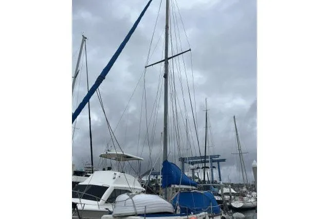 Slide: The Image of 1977 Uniflite Valiant 40 sailboat docked at a marina under cloudy skies. - 39