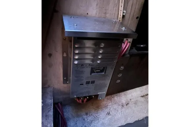 Slide: The Image of Electrical panel inside a 1977 Uniflite Valiant 40 boat, featuring wiring and metal casing. - 47