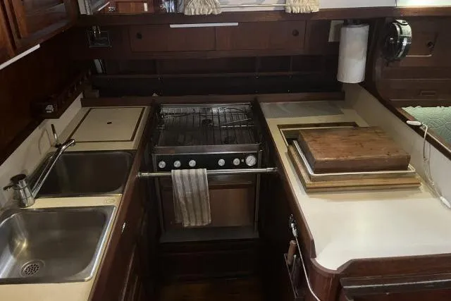 Slide: The Image of 1977 Uniflite Valiant 40 yacht kitchen with stove, sink, and wooden countertops. - 5