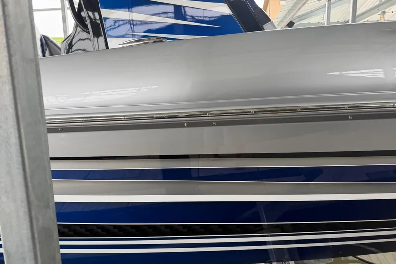 Slide: The Image of 2018 Sunsation 32 CCX boat with sleek gray and blue striped design. - 10