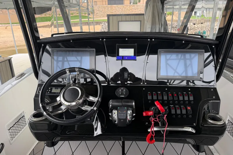 Slide: The Image of 2018 Sunsation 32 CCX boat dashboard with steering wheel, dual screens, and control switches. - 17