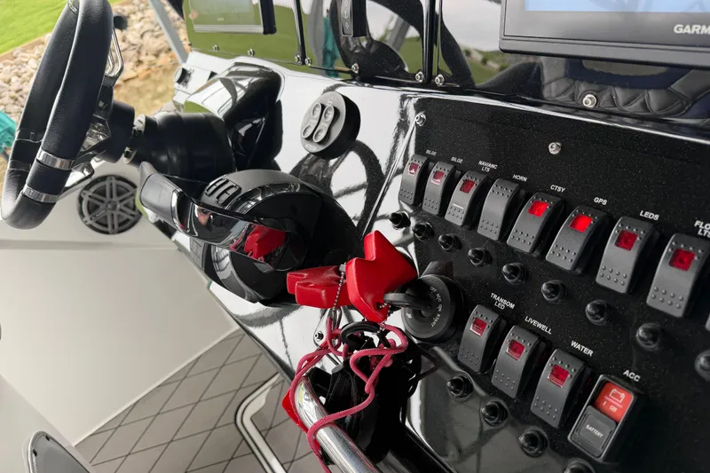 Slide: The Image of Control panel of a 2018 Sunsation 32 CCX boat with switches and steering wheel. - 18