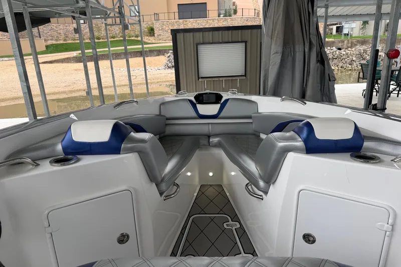 Slide: The Image of 2018 Sunsation 32 CCX boat interior with blue and gray seating, docked in a covered area. - 24