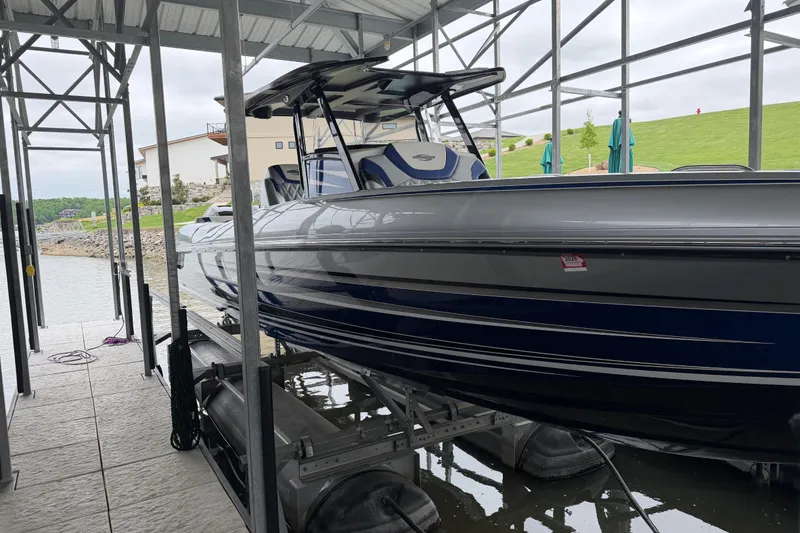 Slide: The Image of 2018 Sunsation 32 CCX boat docked in a covered marina, showcasing sleek design and modern features. - 8