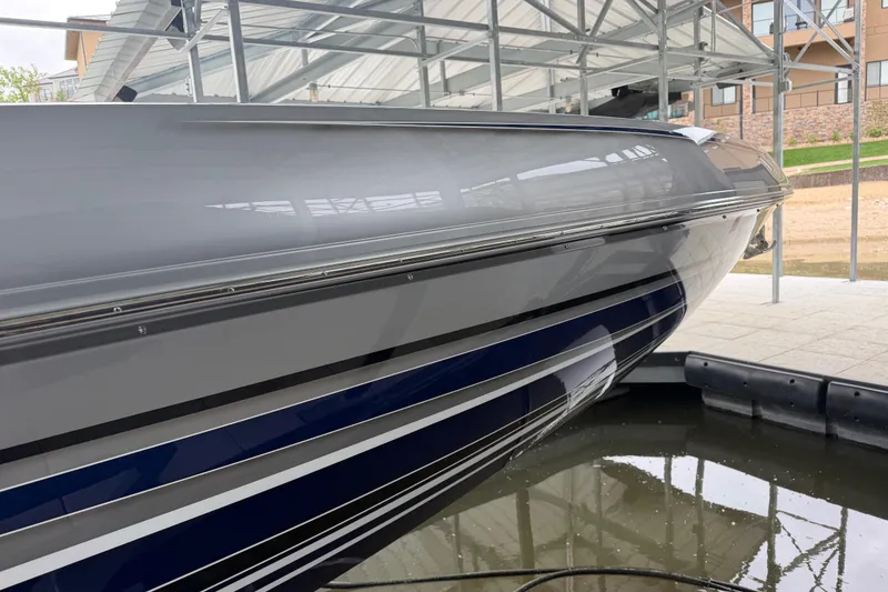 Slide: The Image of 2018 Sunsation 32 CCX boat docked, showcasing sleek design and reflective surface. - 9