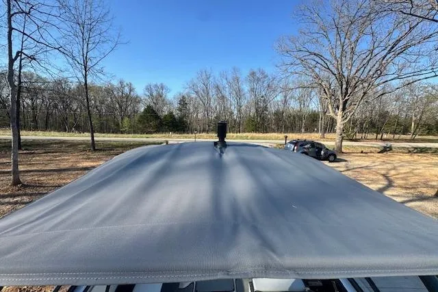 Slide: The Image of 2021 Yamaha AR 210 boat cover in a wooded area with clear blue sky. - 10