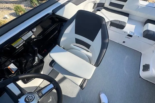Slide: The Image of 2021 Yamaha AR 210 boat interior with steering wheel and seating area. - 15