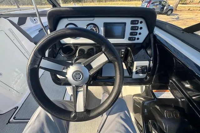 Slide: The Image of 2021 Yamaha AR 210 boat cockpit with steering wheel and control panel. - 16