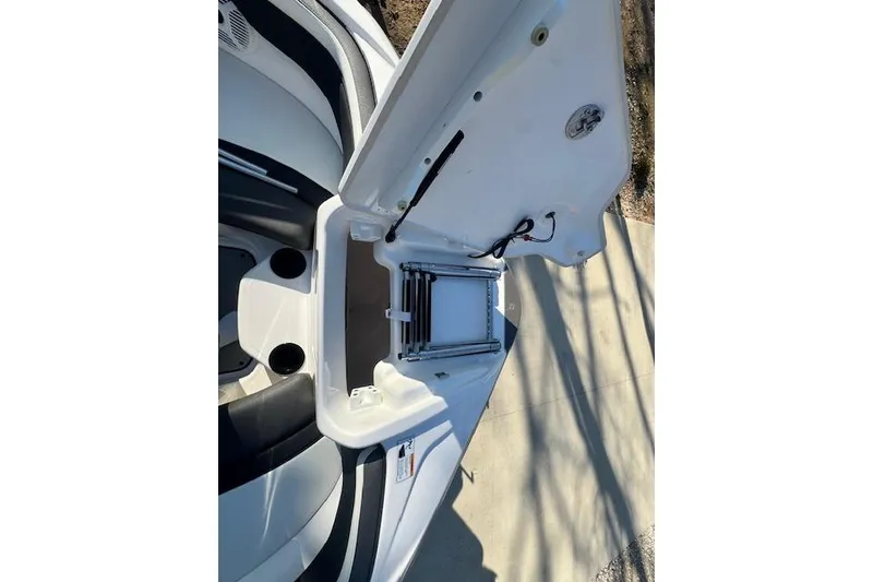 Slide: The Image of 2021 Yamaha AR 210 boat storage compartment with open hatch and ladder. - 25