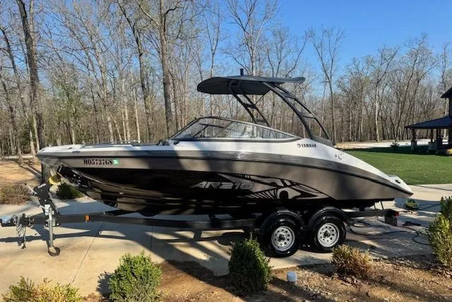 Slide: The Image of 2021 Yamaha AR 210 boat on trailer, parked outdoors in a wooded area. - 3