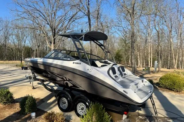 Slide: The Image of 2021 Yamaha AR 210 boat on trailer, parked outdoors in wooded area. - 4