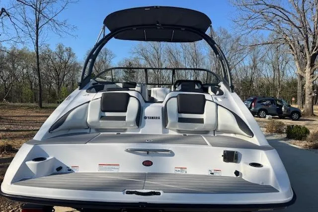 Slide: The Image of 2021 Yamaha AR 210 boat, rear view, parked outdoors with trees in the background. - 5